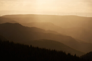 Sunlit mountains and hazy light effects at sunrise in Ulan Butong, China