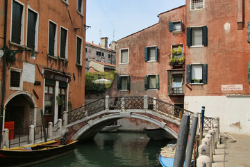 Picturesque Venetian Canal with Bridge and Gondola.  A classic, tranquil scene of an old canal in Venice, Italy. 