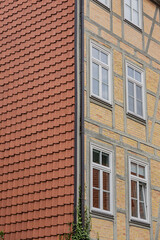 Obraz premium Close up of half timbered house wall with red tiled roof and white framed windows in Göttingen, Germany