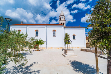 Historic architecture in Biograd, bell tower of St. Anastasia and church backyard with well,...