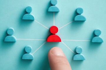 Finger pointing at a red person icon in a network of blue person icons, symbolizing leadership and connection.