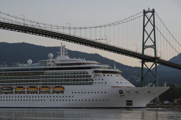 Fototapeta premium Modern cruiseship or cruise ship liner Serenade, Radiance, Brilliance or Jewel arrival into Vancouver port, Canada during sunrise after cruise to Alaska with Stanley Park landscape