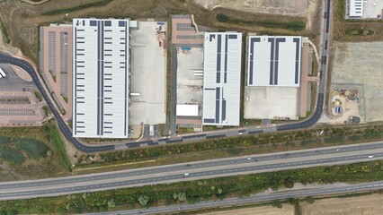 Aerial drone shots of large industrial warehouses, factories and distribution centres with busy...
