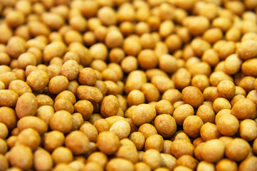 Close-up of delicious peanuts roasted in coconut glaze. Many are lying on the plane