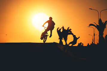 biker in action. Boy making bmx bicycle air trick with grab, silhouette unrecognizable.