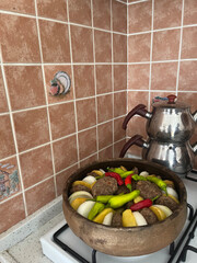 Traditional Turkish meatballs on stove with tea pot