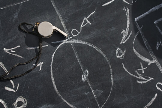 Tactic plan and referee whistle. Hand drawn strategy scheme sketch, isolated on on the black chalkboard.