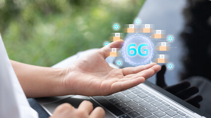 Hand holding a digital hologram of 6G wireless technology with data transfer and high-speed internet connection. Concept of future communication, innovation, and next-generation mobile network.