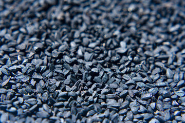 Macro Photo of Black Cumin Seed in a Textured Surface Background