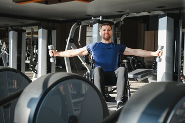 Person with disability lifting weights in wheelchair at gym for rehabilitation
