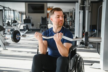 Man with disability lifting weights in a modern gym for rehabilitation