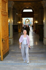 A hot summer evening in Samarkand, Uzbekistan.
Female tourist walks through the old city.
Woman...