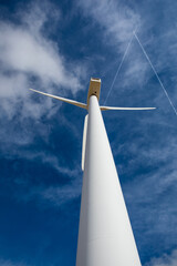 Discovering towering wind turbines against a backdrop of blue skies in a serene landscape