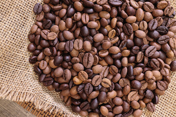 Fresh roasted aromatic arabica coffee bean smoking on rustic jute fabric round mat