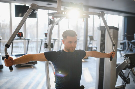 Man doing rehabilitation exercises with pectoral machine in gym