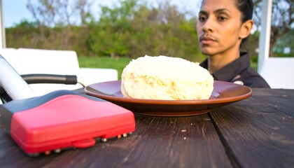 Woman stares at large, light-colored cake on plate
