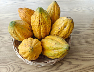 Ripe yellow cocoa pod in a basket on table