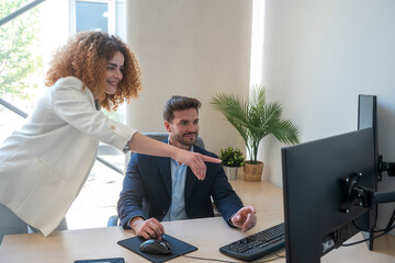 Business colleagues collaborating on computer project in modern office