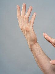 Male Hand Palm Close-Up on Gray Background, Open Gesture