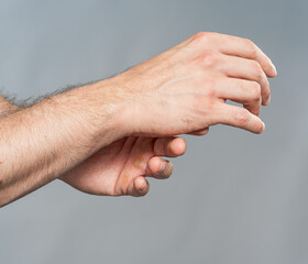 Male Hands Adjusting Wrist Gesture on Neutral Gray Background