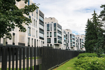 Contemporary residential complex with modern architecture, large windows, and landscaped greenery,...