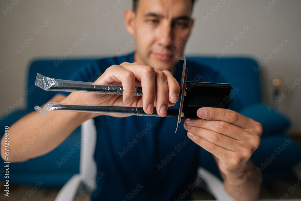 Poster selective focus portrait of technician male assembling wi-fi module by connecting antennas sitting a