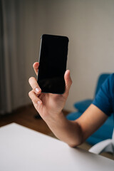 Close-up of male blogger displaying smartphone with blank screen, creating ideal mockup for...
