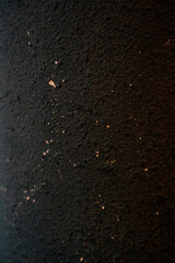 Close-up of textured black wall with subtle paint splatters
