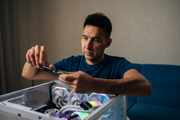 Skilled computer technician inserting wireless network module inside custom desktop computer,...
