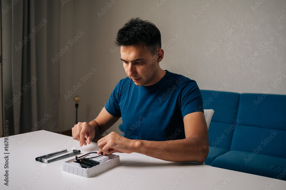 Poster focused technician male assembling wi-fi module using tools at home office desk, focusing on intrica