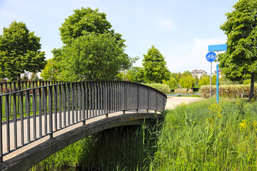 A footbridge crosses the canal and leads to a public park in the Gocław district of Warsaw, Poland
