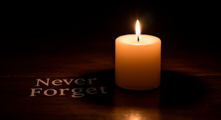 A lit candle with the words never forget on a dark surface casting light and shadows around it