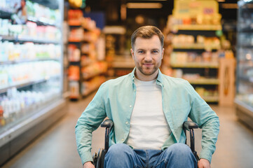 Customer using wheelchair buying groceries in supermarket