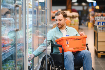 Customer using wheelchair choosing groceries in supermarket refrigerator section