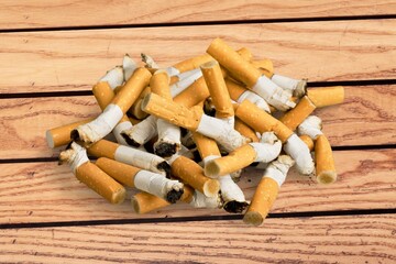 Hand putting cigarette in glass ashtray. Health concept.