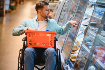 Customer in wheelchair choosing frozen food in supermarket