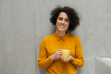 Portrait of beautiful woman with curly hair, gray bacground.