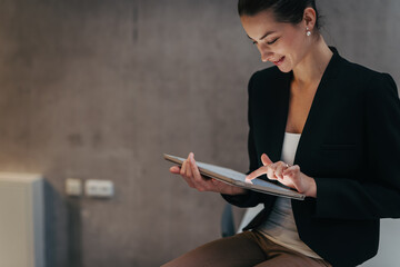 Portrait of young businesswoman working on tablet in office.