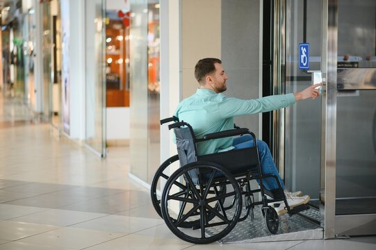 Customer in wheelchair entering store using automatic door button