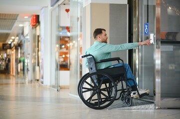 Customer in wheelchair entering elevator in shopping mall © Serhii