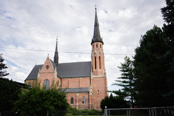 Beautiful historic church of St. Joseph with tall spires in a lush natural setting in Sękowa,...