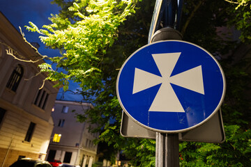 Blue traffic sign with cross symbol in Rzeszow, Poland during evening