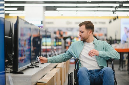 Customer in wheelchair choosing television in electronics store