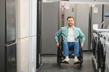 Smiling customer using wheelchair choosing home appliances in electronics store