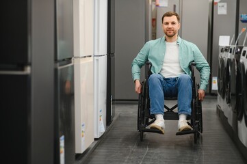 Customer using wheelchair choosing home appliances in electronics store