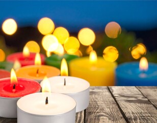 Colorful candles on a wooden surface with a blurred bokeh background