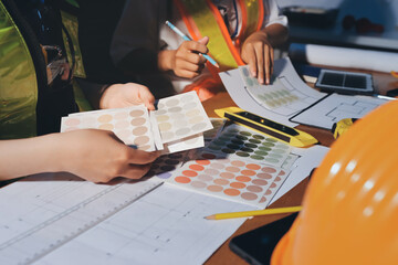 Closeup of team of industrial engineers meeting analyze machinery blueprints consult project on...