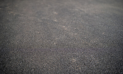 Close-up of a textured asphalt surface showcasing dark gray tones.