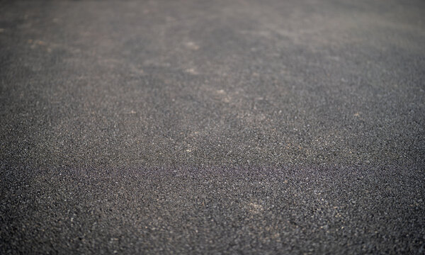 Close-up of a textured asphalt surface showcasing dark gray tones.