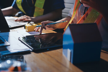 Closeup of team of industrial engineers meeting analyze machinery blueprints consult project on...